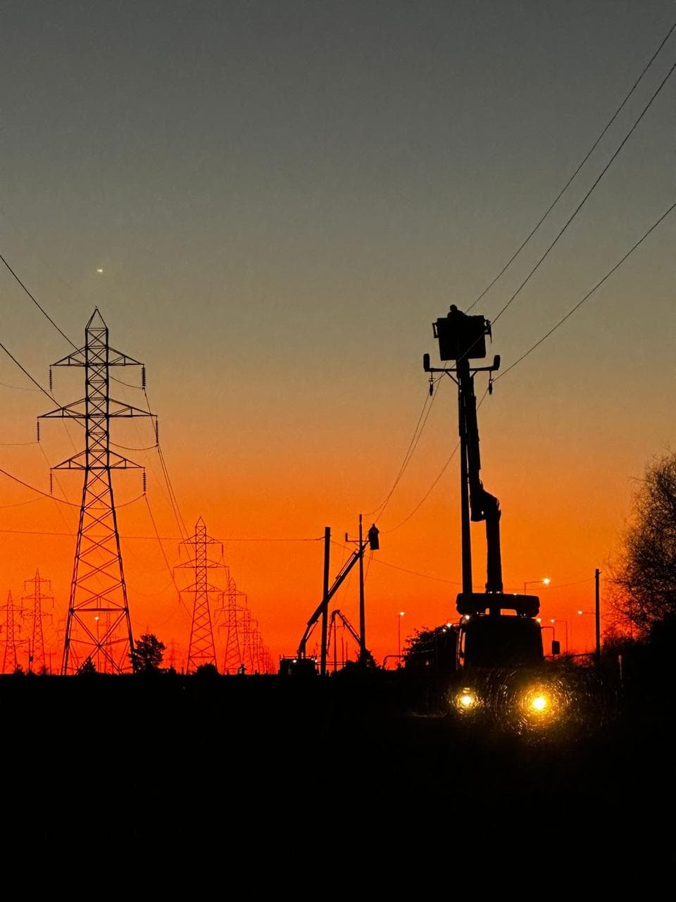 Torre de alta tensión con el sol naciente de fondo